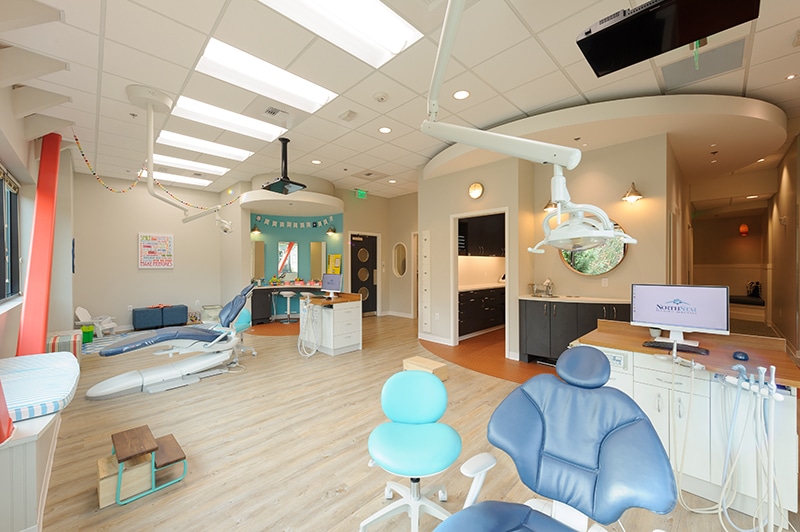 Modern kids dentist office in Mill Creek with two examination chairs, workstations, and equipment.
